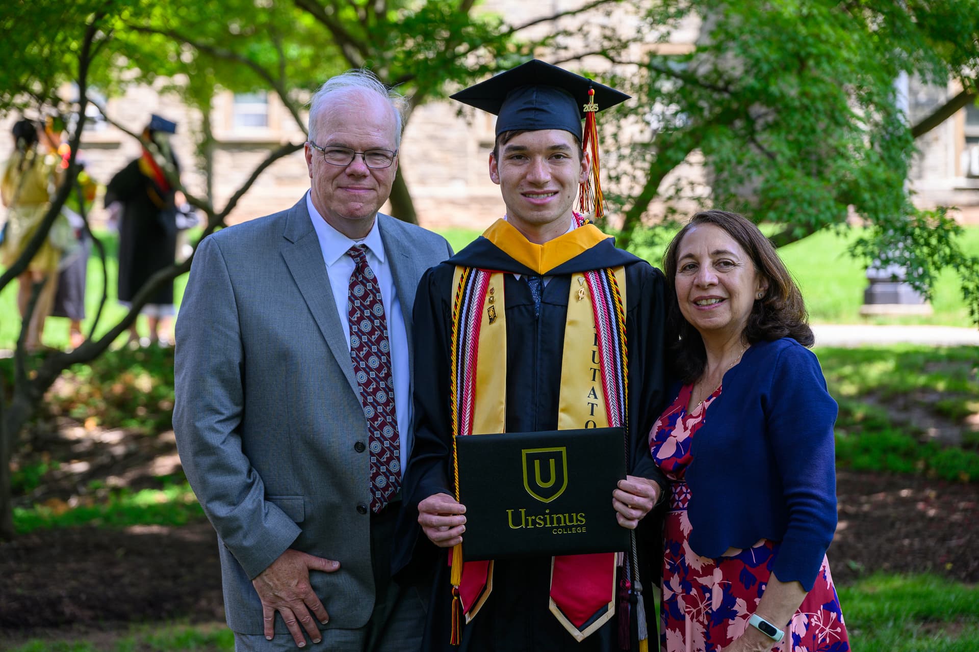 William and his parents attending his undergraduate commencement ceremony.